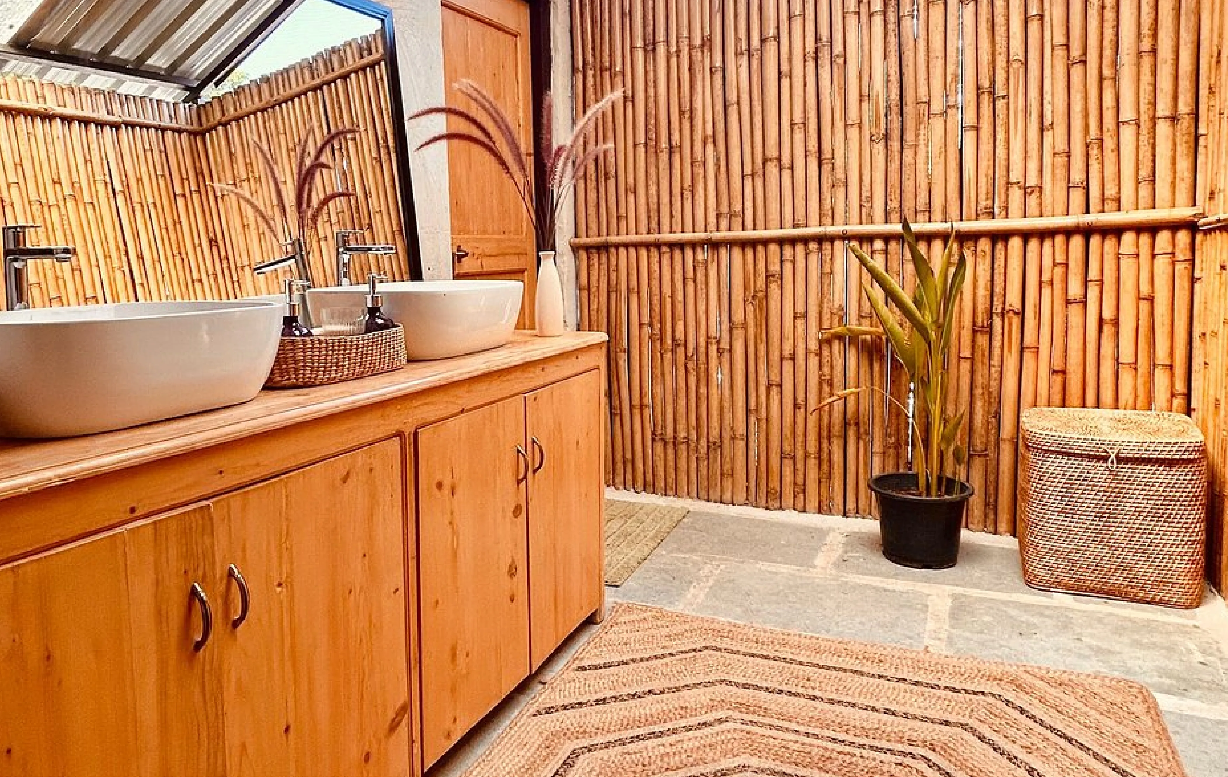 Rustic bathroom with bamboo walls, wooden cabinetry, and double sinks for a serene, natural vibe at Dhyaana Farms a Boutique Hotel in Aurangabad