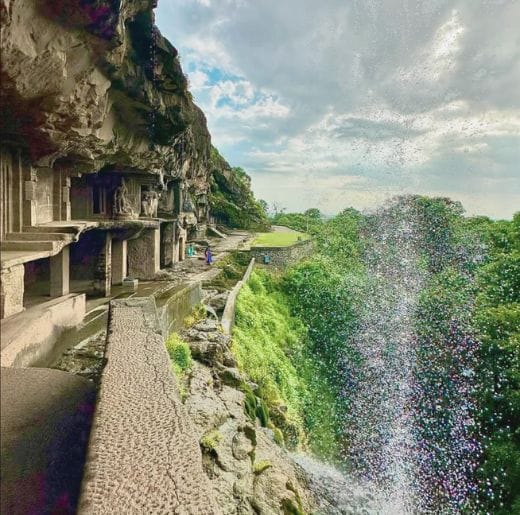 Experiences 7 Ancient rock-cut Ajanta & Ellora Caves with a cascading waterfall and lush greenery, offering a breathtaking exploration experience with Dhyaana Farms