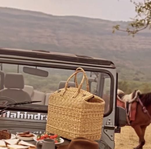 Experiences 8 Scenic picnic setup on a jeep with a wicker basket, fresh food, and a mountain backdrop, perfect for outdoor excursions with Dhyaana Farms