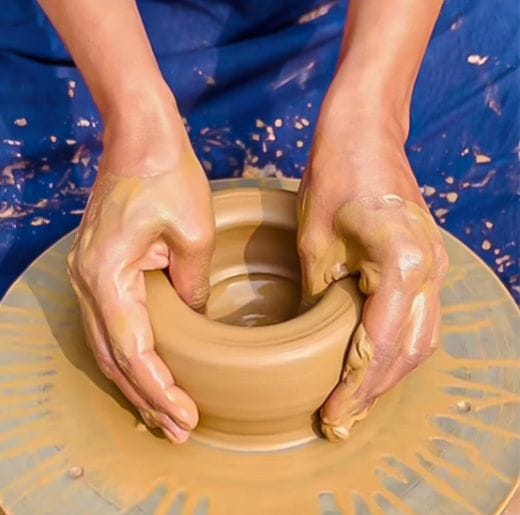 Experiences 2 Hands shaping clay on a pottery wheel during a hands-on workshop at Dhyaana Farms the farmstay in Aurangabad