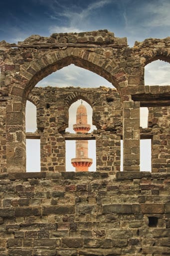 Ruins of Daulatabad Fort, Maharashtra, framing Chand Minar through ancient stone arches, showcasing medieval Deccan architecture.